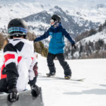 Moniteur expliquant un virage à son groupe pendant un cours de snowboard à Vars et Risoul