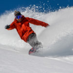 Élève snowboardeur réalisant une grande courbe en hors-piste à Vars et Risoul