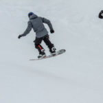 Élève snowboardeur réalisant un petit saut sur piste à Vars et Risoul